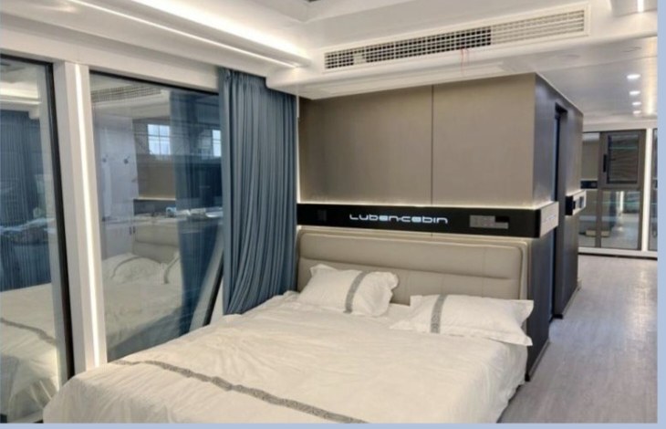 Cabin bedroom with double bed, integrated cabinetry and full-height glazing