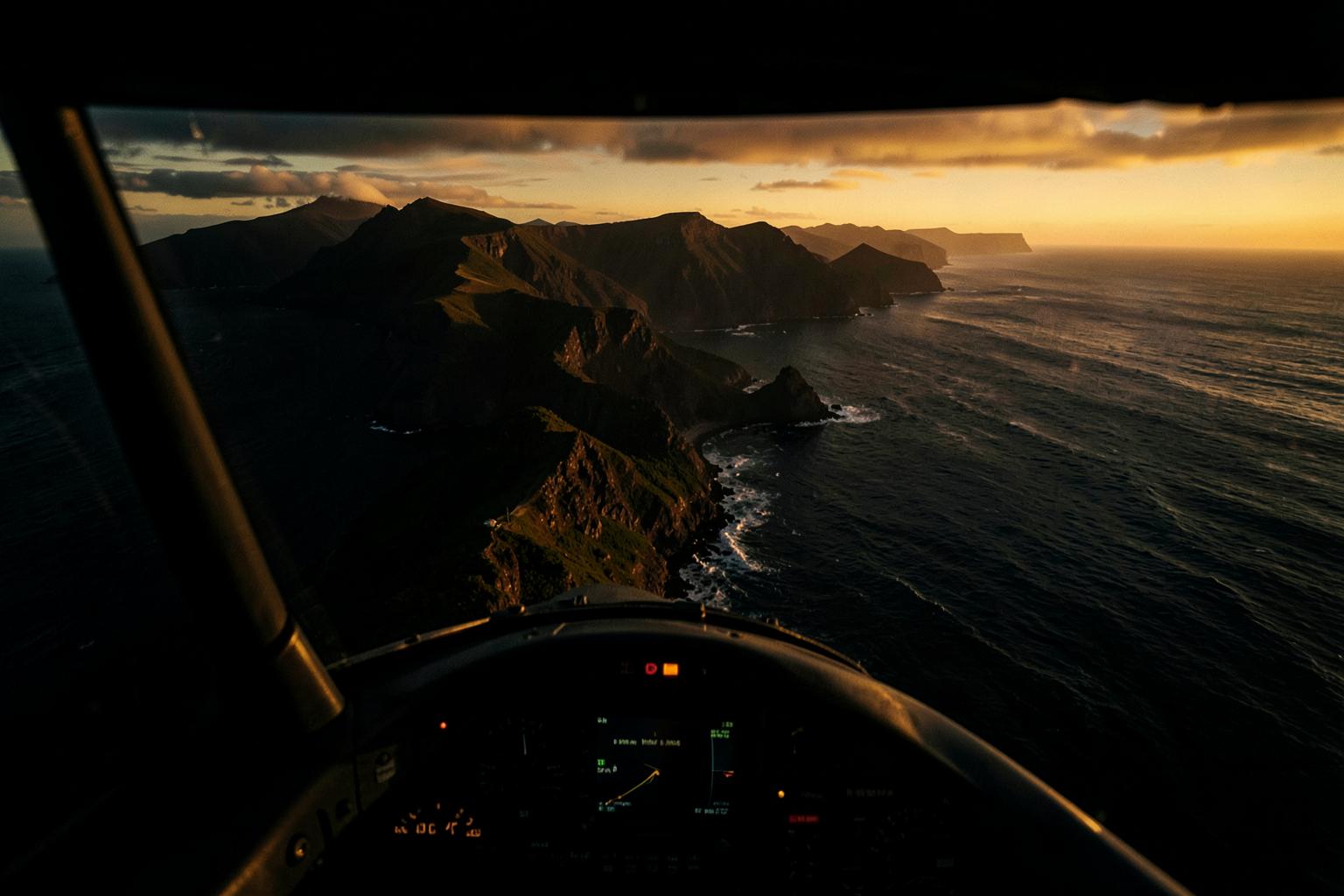 View from a light aircraft cockpit over a rugged coastline at golden hour